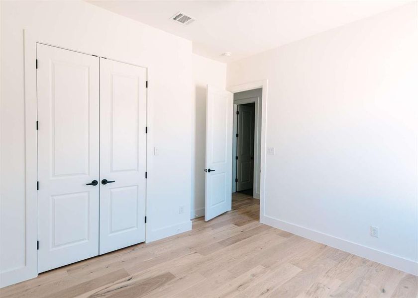 Unfurnished bedroom featuring a closet and light hardwood / wood-style floors