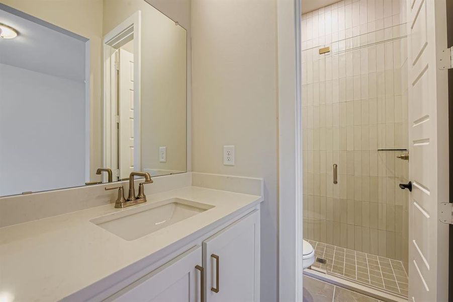 Full bath with vanity, a stall shower, and dark tile patterned floors