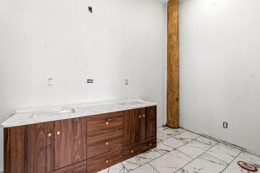 Tastefully selected tile and dual-sink vanity in the primary ensuite.