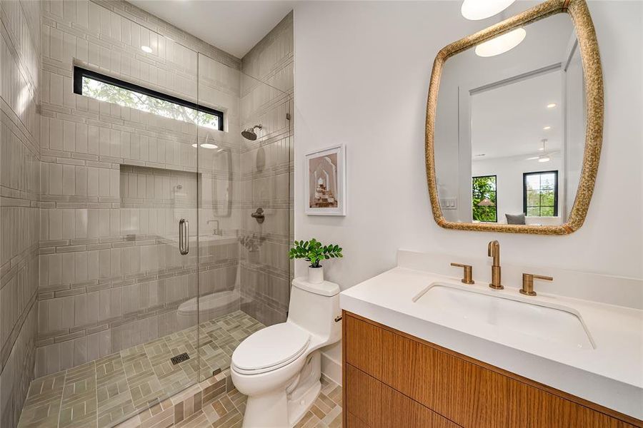 Bathroom with a stall shower, vanity, and recessed lighting Bathroom with a stall shower, vanity, and recessed lighting