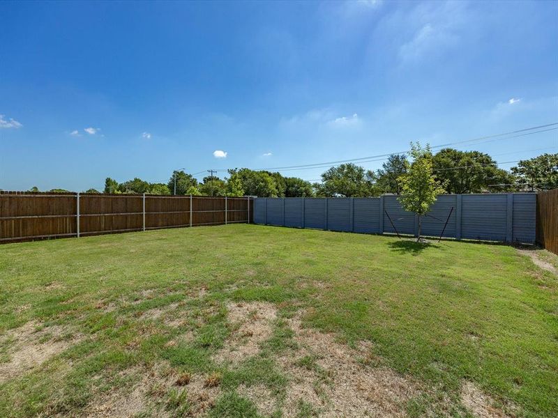 Expansive backyard featuring a combination of wood and composite fencing