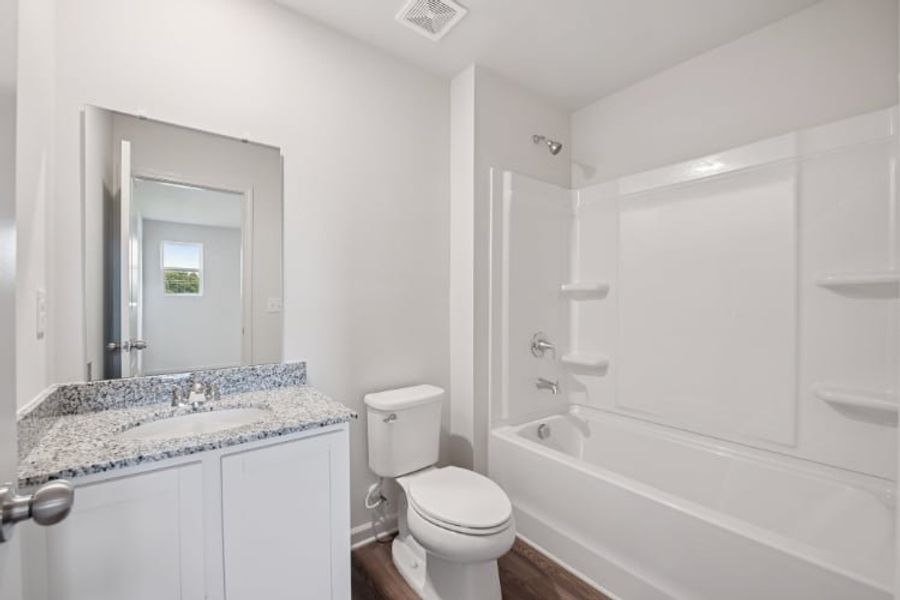 A bathroom with a tub toilet and sink.