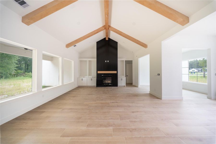 High vaulted ceilings in family room with built in cabinetry on both sides of fireplace