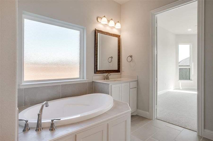 Bathroom featuring vanity, a tub, and tile patterned floors