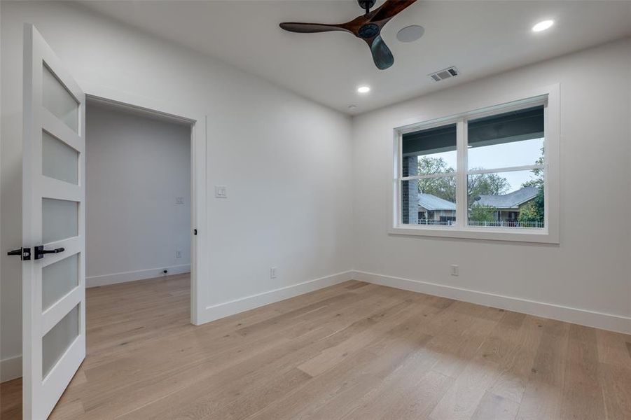 Empty room with light wood-type flooring, a ceiling fan, and recessed lighting