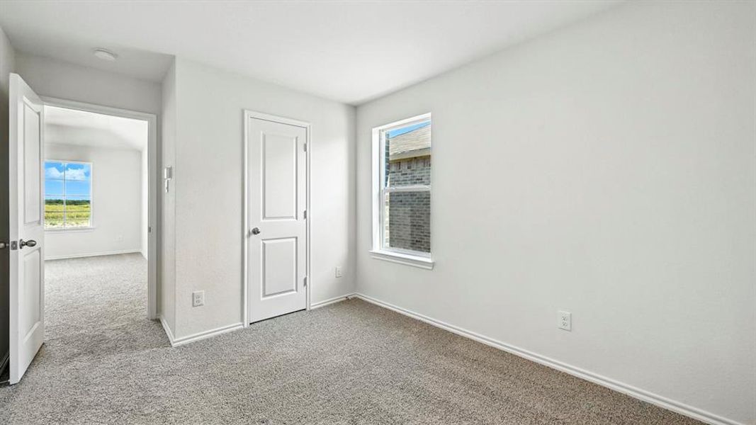 Carpeted room featuring white walls, white trim, and a window providing natural light