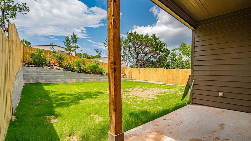 Fenced backyard with covered patio