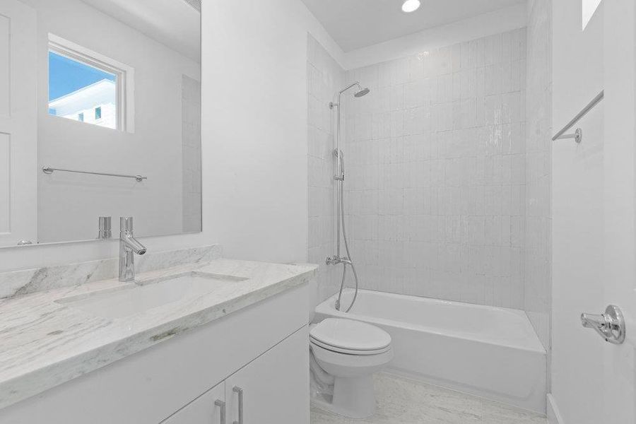 Bathroom with vanity, washtub / shower combination, and recessed lighting