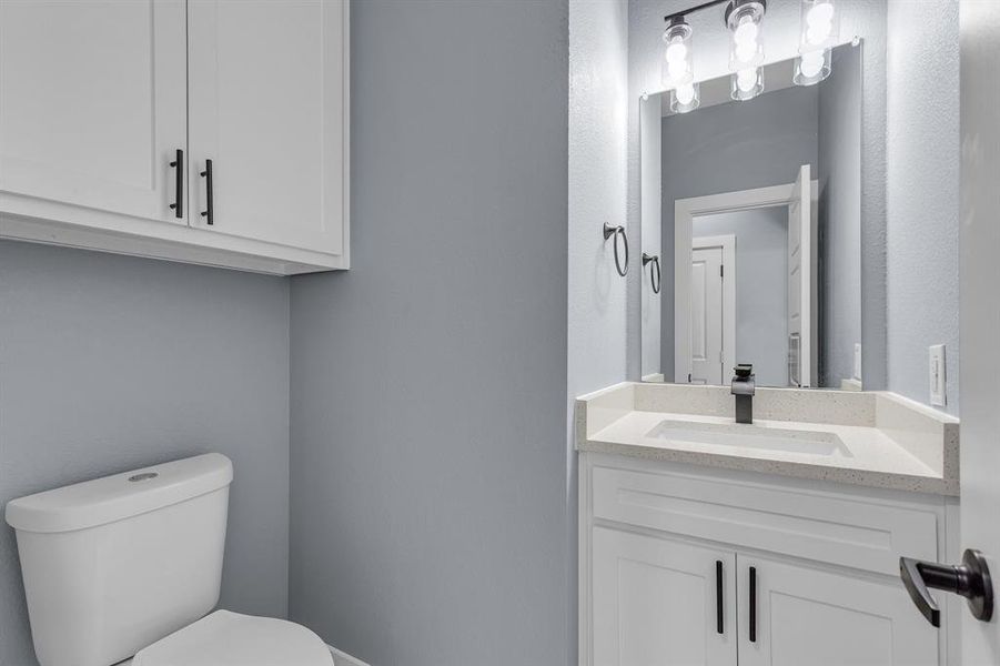 Bathroom with toilet and vanity with extensive cabinet space