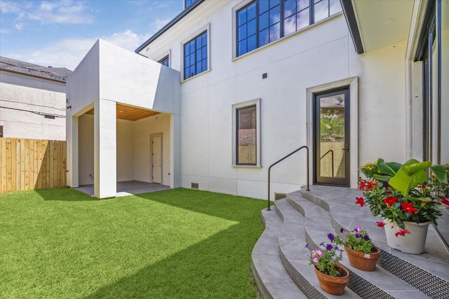 Such an attractive entrance from the family room/den to the outdoor space--down these steps and onto the grassy area and them looking to the covered patio.  That is the 2nd floor balcony located above the covered patio.