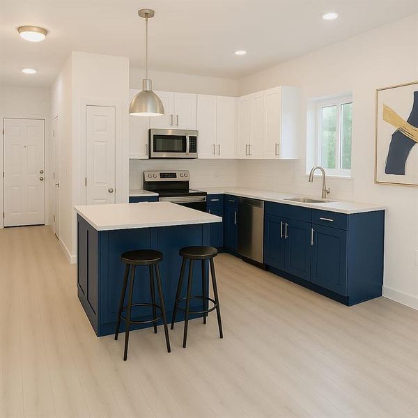 Kitchen featuring blue cabinets, stainless steel appliances, a sink, light wood-style floors, and light countertops Kitchen featuring blue cabinets, stainless steel appliances, a sink, light wood-style floors, and light countertops
