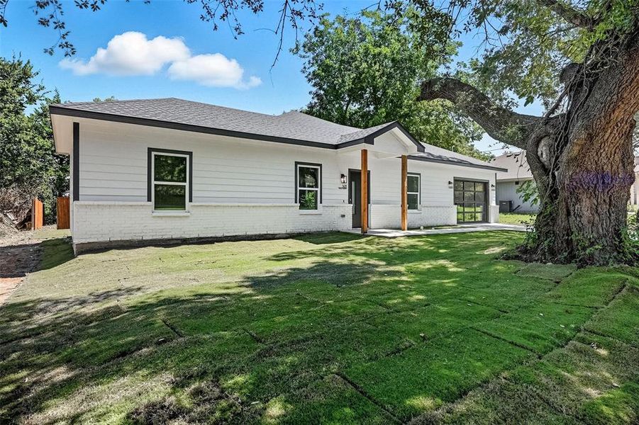View of front of property featuring brick siding, a front yard, and a shingled roof View of front of property featuring brick siding, a front yard, and a shingled roof