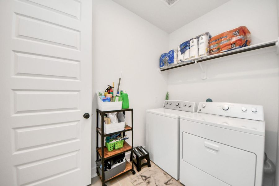 Spacious utility room with upper shelving.
