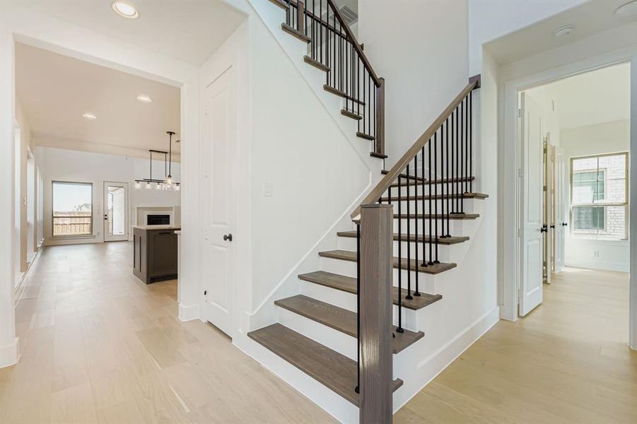 Stairway featuring plenty of natural light, wood finished floors, and recessed lighting Stairway featuring plenty of natural light, wood finished floors, and recessed lighting
