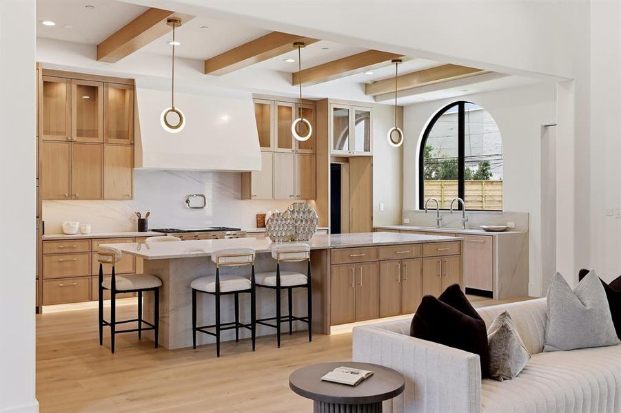 The chef’s kitchen is a masterpiece, featuring a Wolf steam oven, a built-in Miele coffee maker, Bianco Superiore Quartzite countertops, a 48-inch range, and SubZero refrigerator and freezer units
