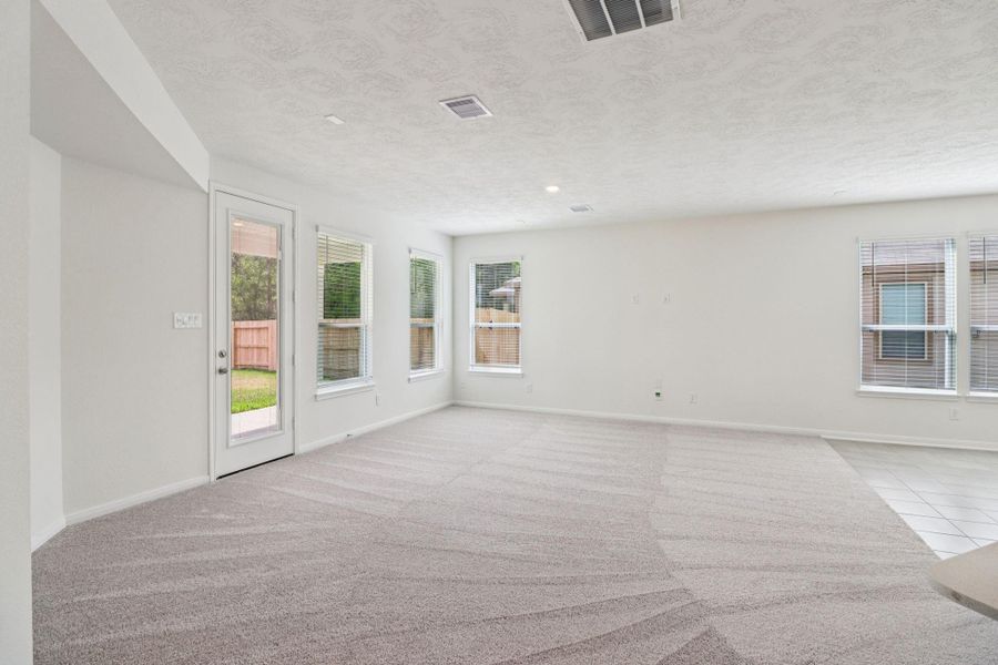 Gather the family and guests together in your lovely family room! Featuring high ceilings, recessed lighting, custom paint, gorgeous tile floors, large windows with blinds, and an access door to the covered patio and backyard.