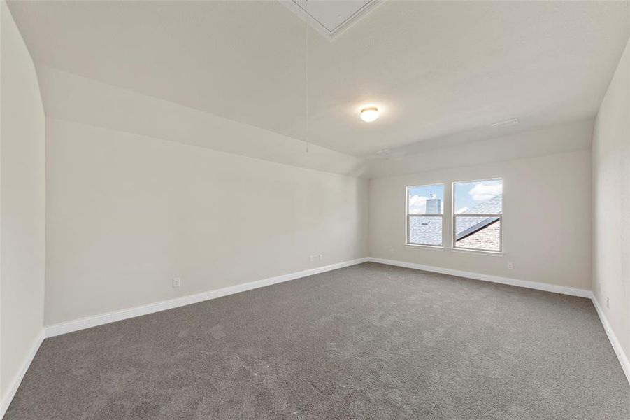 Carpeted empty room with lofted ceiling