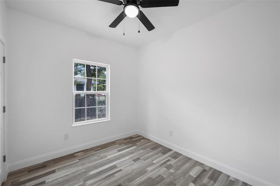 Empty room featuring light wood-type flooring and a ceiling fan