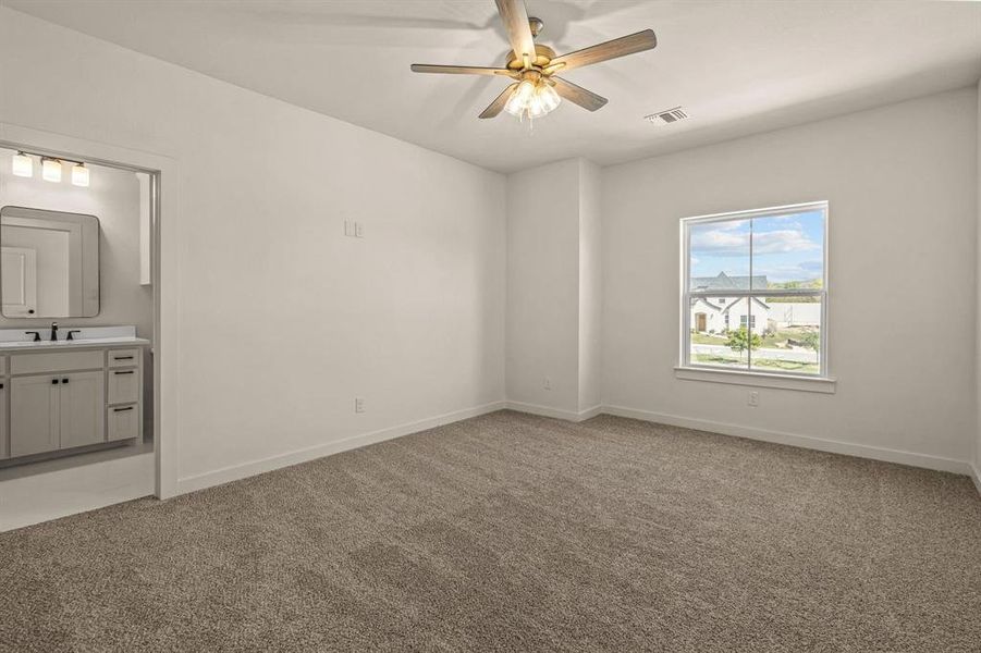 Unfurnished bedroom with a sink, light colored carpet, baseboards, and ensuite bath