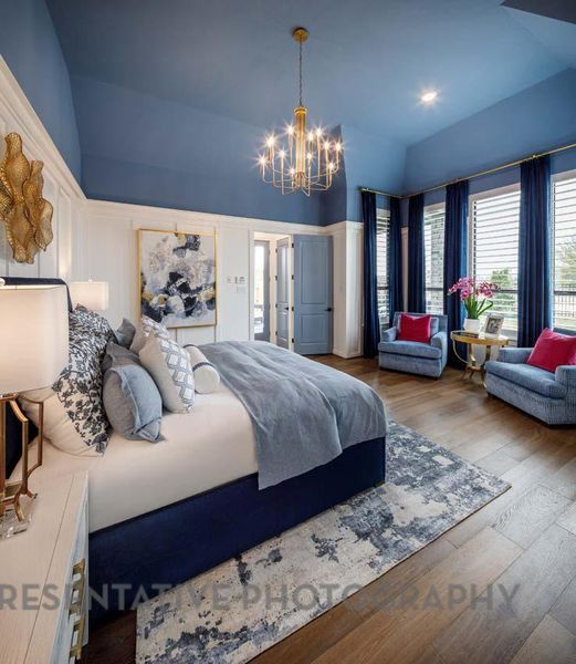 Bedroom featuring a chandelier, wood finished floors, and lofted ceiling Bedroom featuring a chandelier, wood finished floors, and lofted ceiling