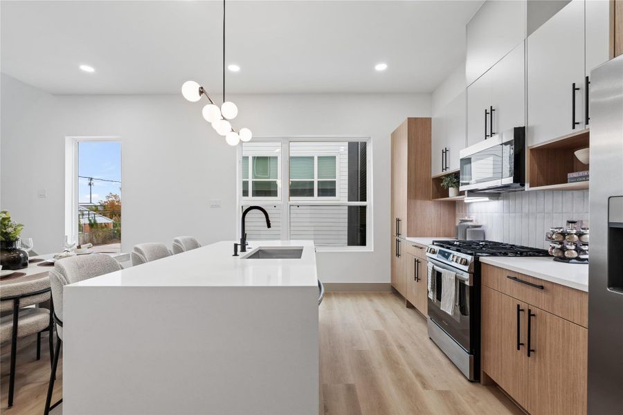 This statement island does it all—prep, serve, sip your morning coffee or gather with friends. Wrapped in a waterfall quartz slab with slatted wood detail and matte black fixtures, it's where everyday routines feel a little more luxurious.