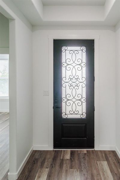 Ornate wrought iron detailing adorns the entry door, creating a sophisticated and welcoming first impression. Ornate wrought iron detailing adorns the entry door, creating a sophisticated and welcoming first impression.