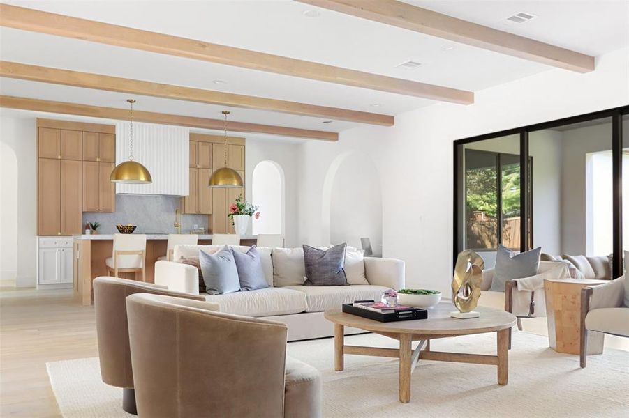 Living room featuring light hardwood / wood-style floors and beamed ceiling