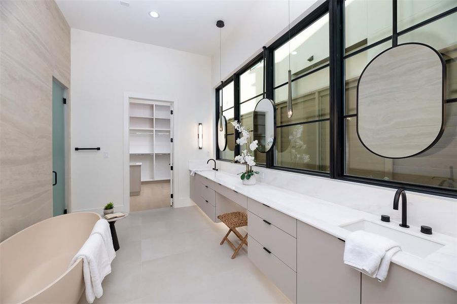 Bathroom with double vanity, a spacious closet, a freestanding bath, recessed lighting, and a stall shower
