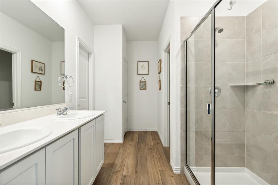 Primary bath features walk in shower, dual sinks, and a large walk in closet.