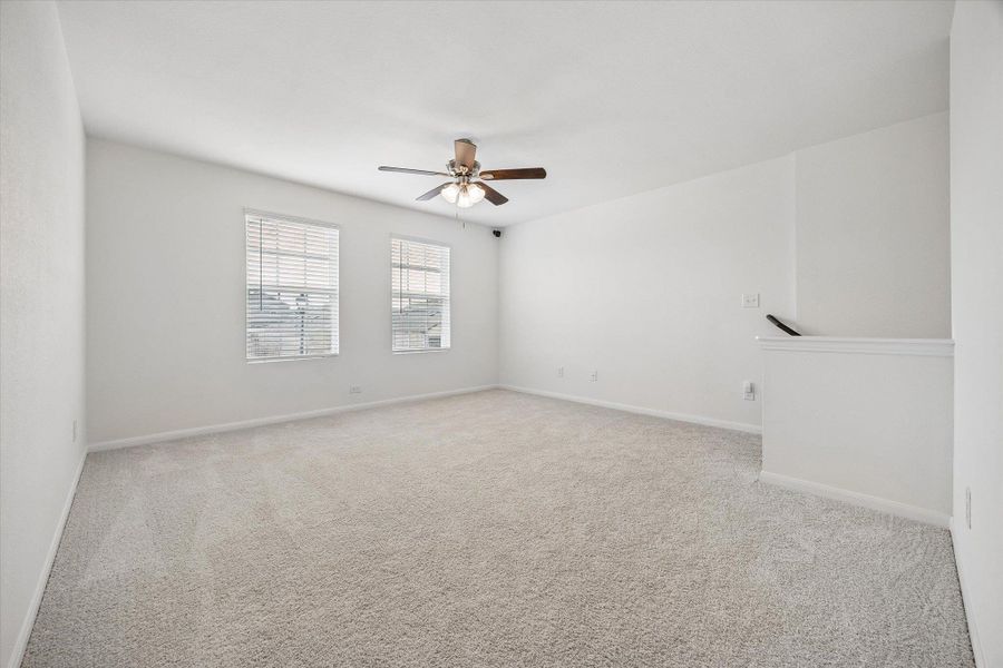 Unfurnished room with light carpet and ceiling fan