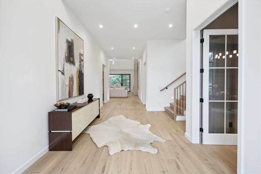 Step inside to a grand foyer with soaring ceilings and modern hardwood floors that flow throughout the home. Large windows in the open-concept layout offer abundant natural light, creating a warm and inviting atmosphere.