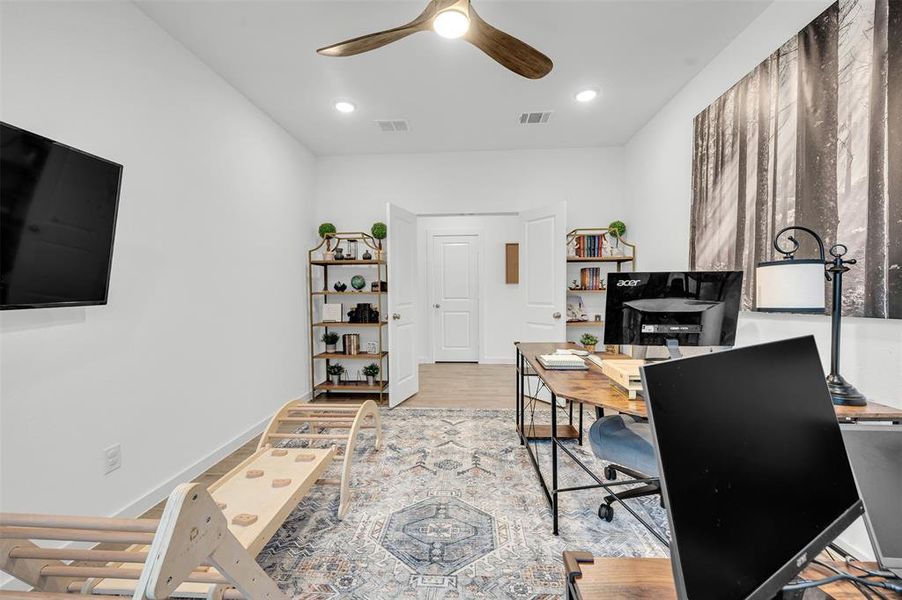 Office space featuring ceiling fan and light hardwood / wood-style floors