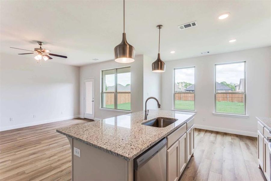 Kitchen with dishwasher, pendant lighting, a center island with sink, sink, and plenty of natural light