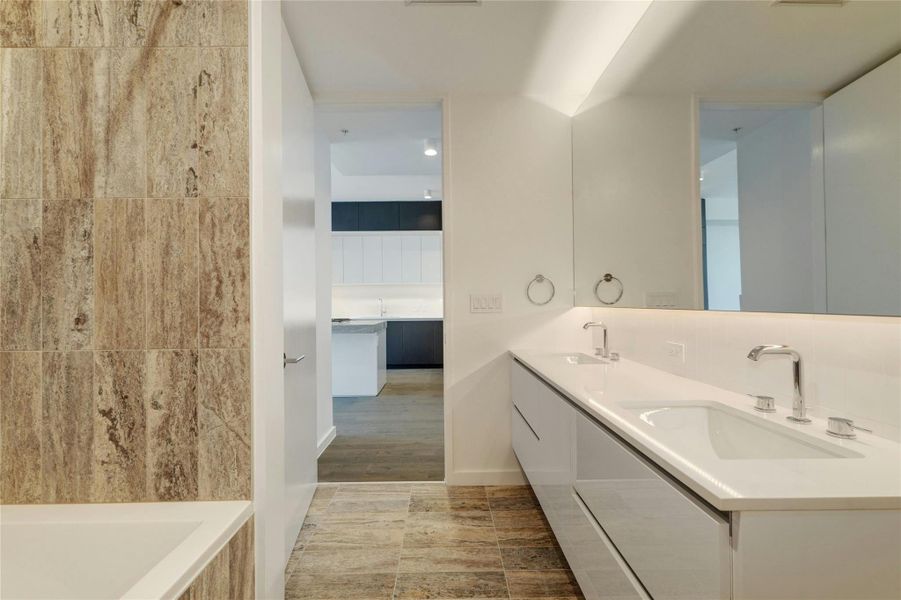 Full bath with double vanity and tiled tub