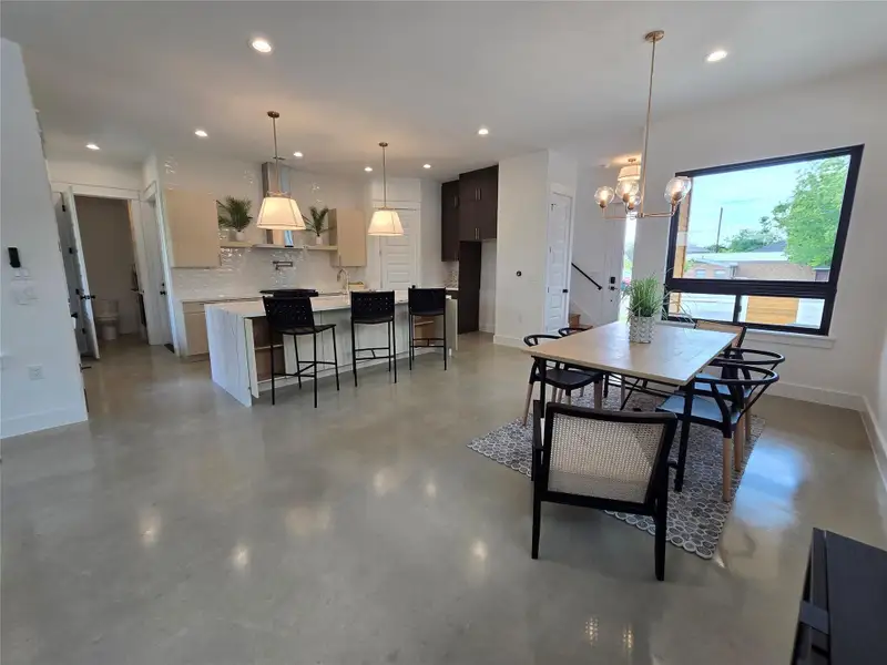 Dining room featuring recessed lighting, concrete floors, an inviting chandelier, and baseboards Dining room featuring recessed lighting, concrete floors, an inviting chandelier, and baseboards