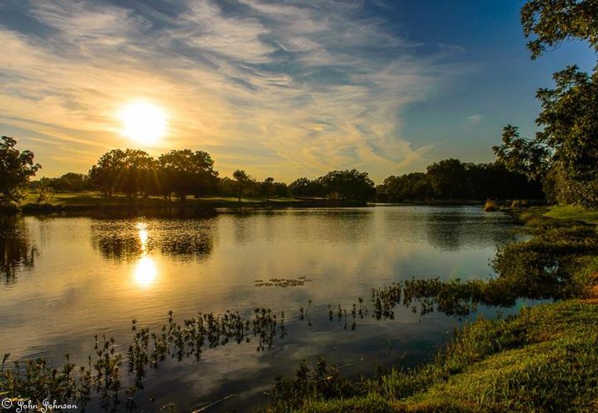 Golden hour illuminates a tranquil lake, reflecting the vibrant sky and lush shoreline. Golden hour illuminates a tranquil lake, reflecting the vibrant sky and lush shoreline.