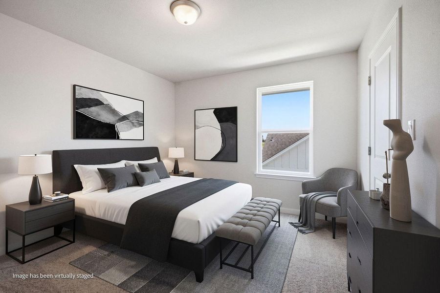 Natural light streams through a large window onto soft carpeting in this peaceful bedroom. Natural light streams through a large window onto soft carpeting in this peaceful bedroom.