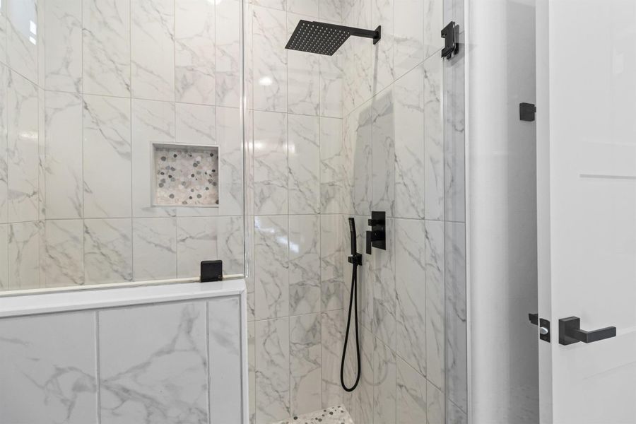 Full bath with a marble finish shower