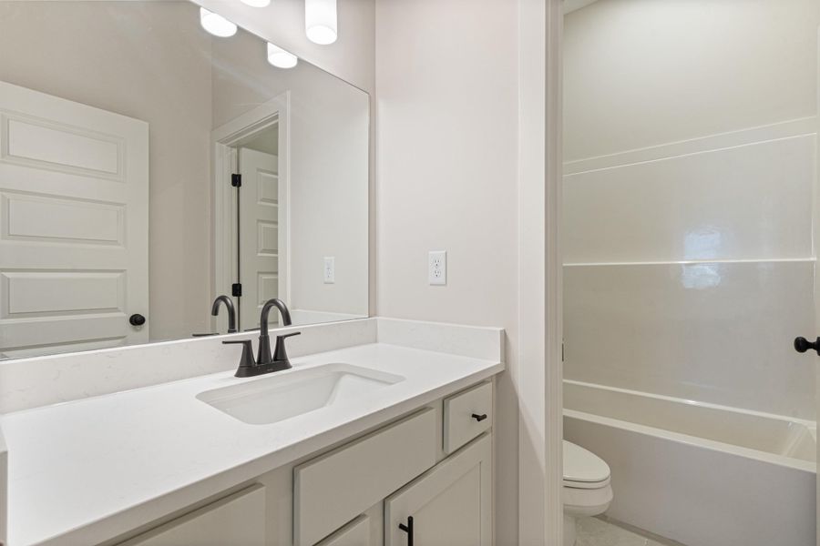 White vanity with integrated sink, matte black faucet, and white countertop White vanity with integrated sink, matte black faucet, and white countertop
