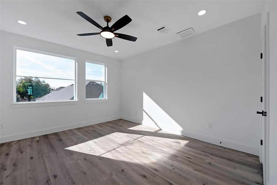 The nice-sized primary bedroom features large windows that bring in plenty of natural light. The room can easily fit a king bed. The door to the right is one of two closets.