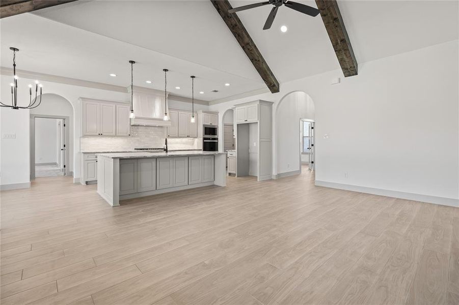 Kitchen featuring arched walkways, recessed lighting, ceiling fan, stainless steel microwave, and backsplash Kitchen featuring arched walkways, recessed lighting, ceiling fan, stainless steel microwave, and backsplash