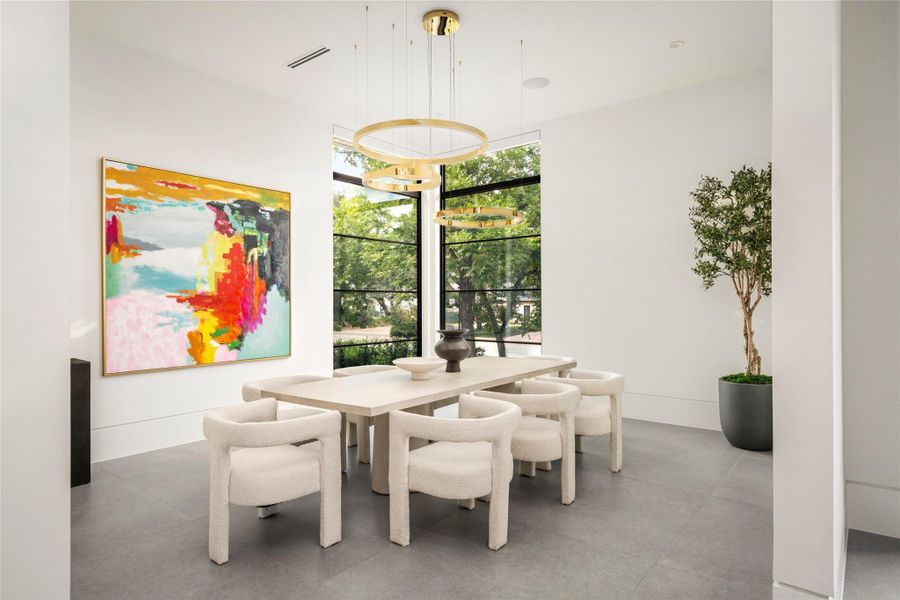 [Dining Room] Floor-to-ceiling corner windows and a sculptural chandelier set the tone in the dining room, which sits just off the foyer for effortless entertaining.
