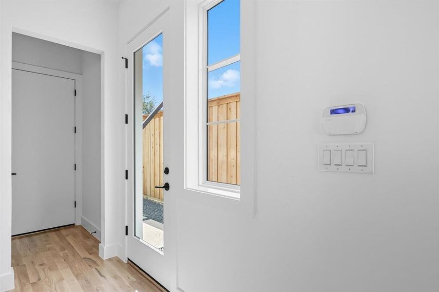 Doorway to outside featuring wood finished floors and baseboards Doorway to outside featuring wood finished floors and baseboards