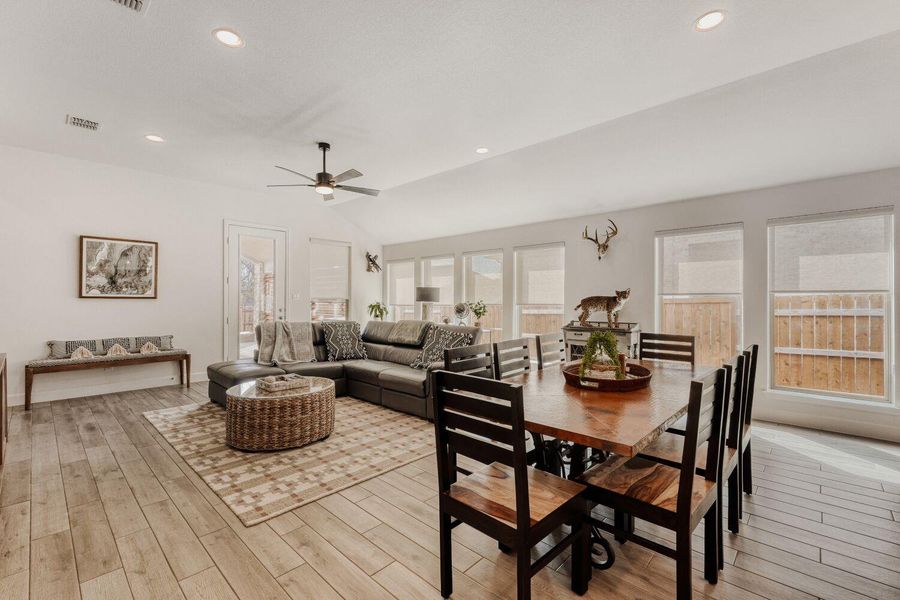 Dining space with lofted ceiling, a ceiling fan, light wood-type flooring, and recessed lighting