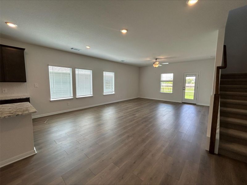 Unfurnished living room with recessed lighting, stairs, dark wood finished floors, and a ceiling fan