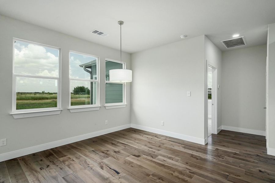 Unfurnished dining area with wood finished floors and baseboards Unfurnished dining area with wood finished floors and baseboards