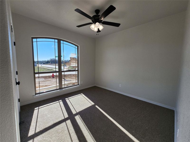 Carpeted spare room featuring baseboards and a ceiling fan