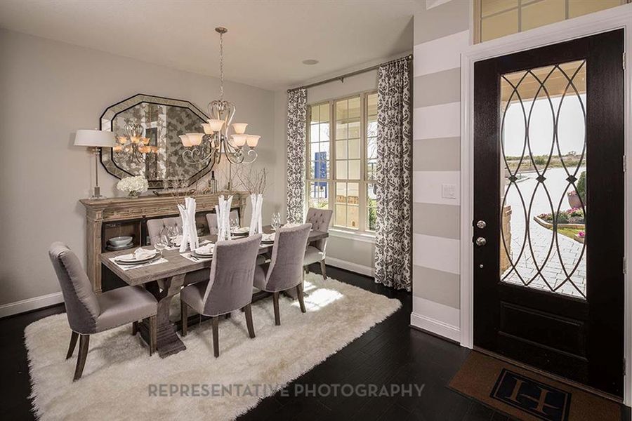 Dining area featuring dark wood-type flooring and a chandelier Dining area featuring dark wood-type flooring and a chandelier
