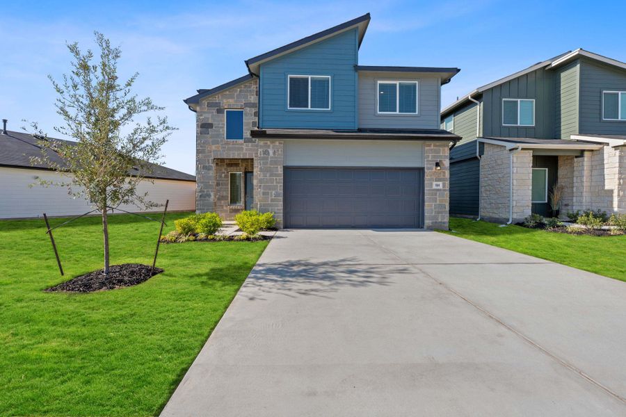 Contemporary house featuring stone siding, a front lawn, concrete driveway, and an attached garage Contemporary house featuring stone siding, a front lawn, concrete driveway, and an attached garage