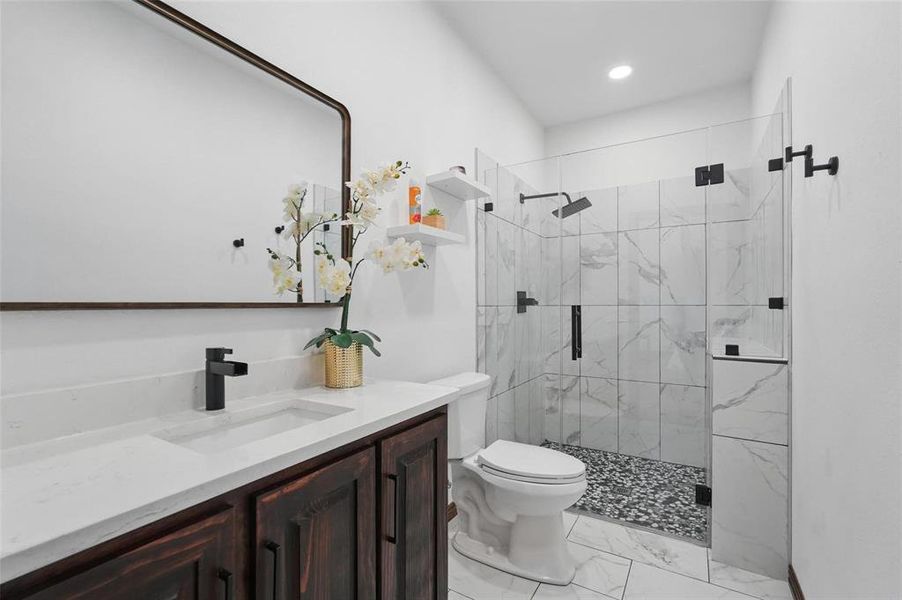 Full bathroom with vanity, light marble finish floors, a marble finish shower, and recessed lighting Full bathroom with vanity, light marble finish floors, a marble finish shower, and recessed lighting